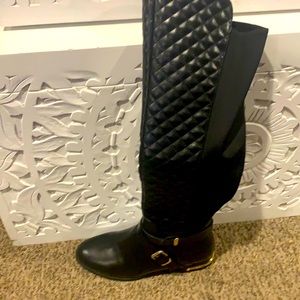 Black knee boots with gold accents